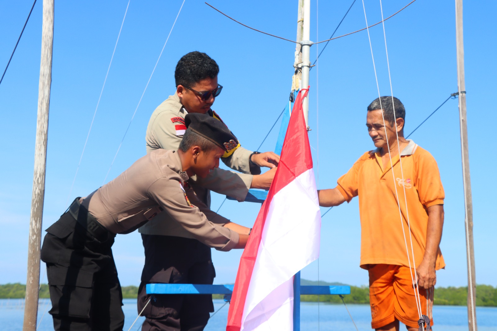 Satpolairud Polres Natuna Bagikan Bendera Merah Putih ke Nelayan di Pelabuhan Pering, Semarakkan HUT ke-81 RI