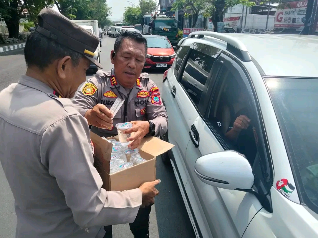 Kapolsek Maesa Bagikan Air Minum ke Pengemudi di Antrean SPBU Bitung Saat Cuaca Panas