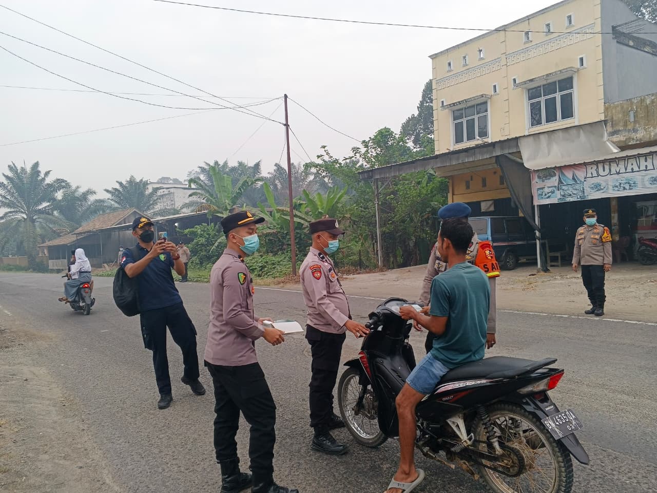 Polsek Sanga Desa Bagikan Masker ke Warga di Depan Mapolsek, Antisipasi Kabut Asap Tebal
