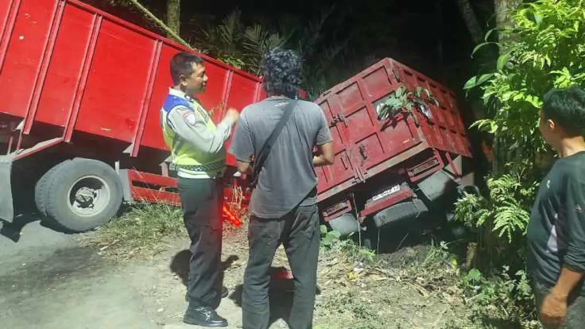 Truk Pasir Rem Blong di Jalan Menurun Bebandem Karangasem, Tabrak Truk Lain dan Terperosok ke Kebun