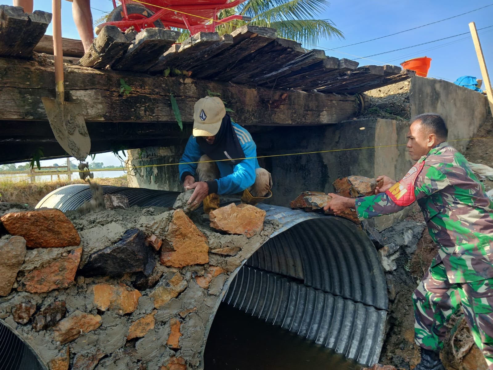 Babinsa Koramil Mandonga Kendari dan Warga Gotong Royong Cor Cakar Ayam Jembatan Beton di Kelurahan Kadia