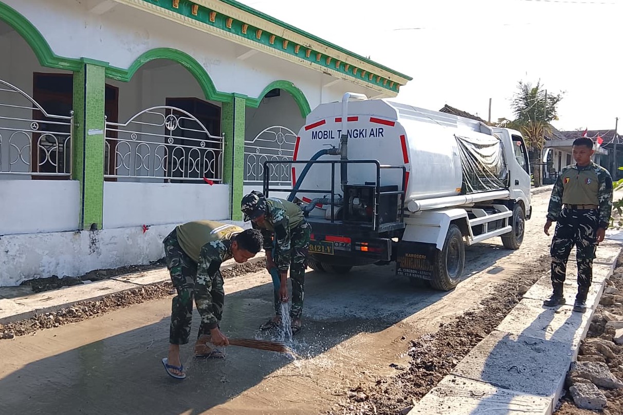Satgas TMMD 129 Bojonegoro Siram Jalan Cor di Depan Masjid Desa Kesongo, Ini Tujuannya