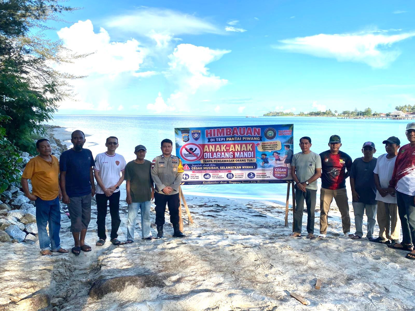Bhabinkamtibmas dan Aparatur Kelurahan Batu Hitam Pasang Spanduk Imbauan Keselamatan Anak di Pantai Piwang Natuna