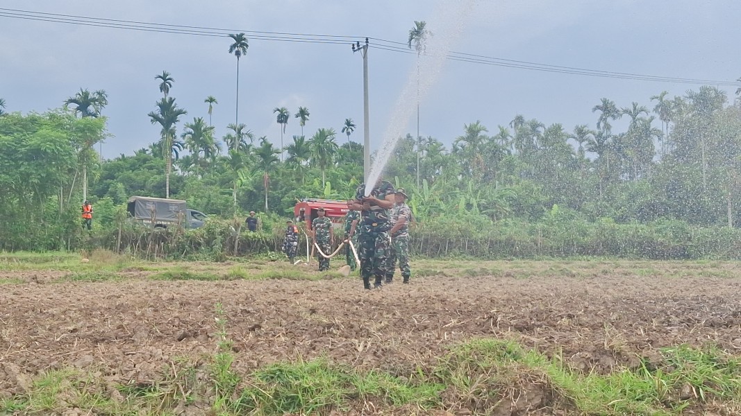 Terik Matahari Tak Halangi Satgas TMMD Kodim 0102/Pidie Siram Benih Jagung dengan Armada Damkar TNI AD